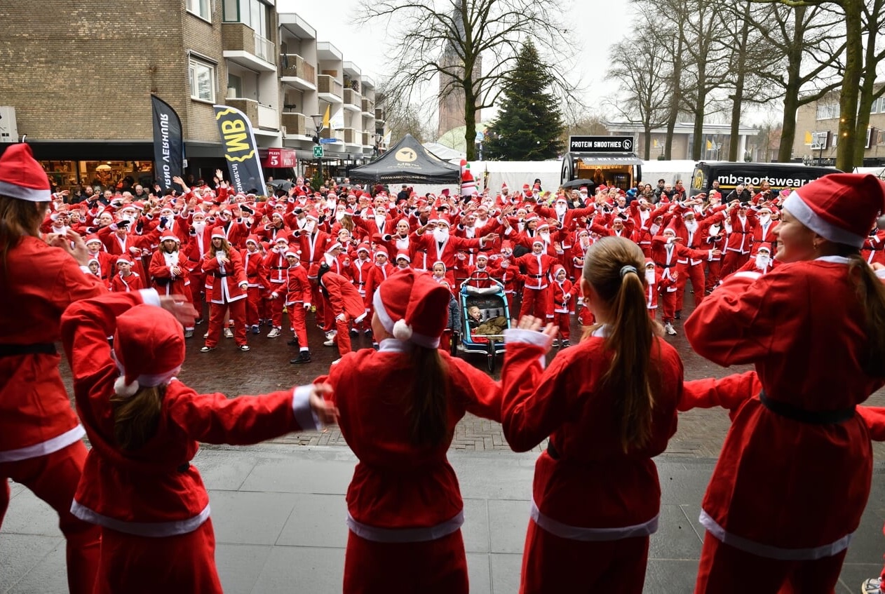 Honderden kerstmannen en -vrouwen tijdens de Santa Run op het dorpsplein van Son en Breugel